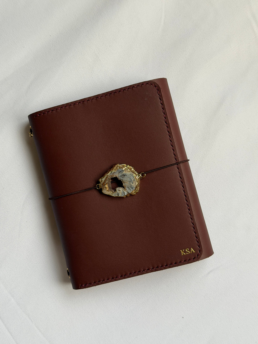 Heatherfield A6 leather journal held in hand in caramel leather