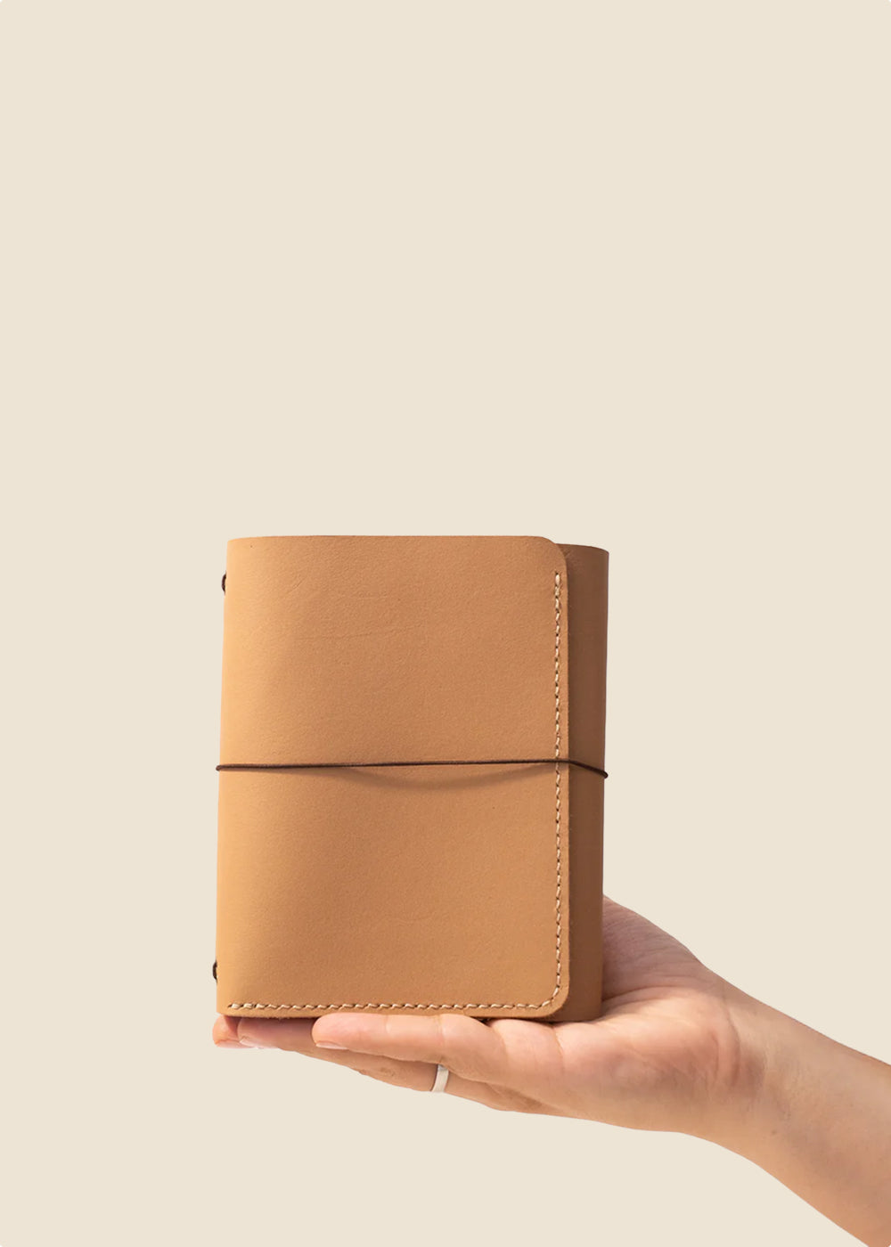 Heatherfield A6 leather journal held in hand in caramel leather
